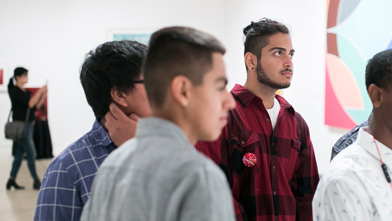 young men looking at paintings