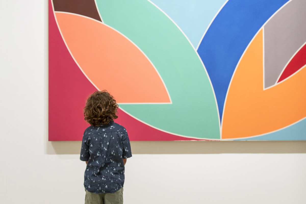 Child looking up at large work of art on wall