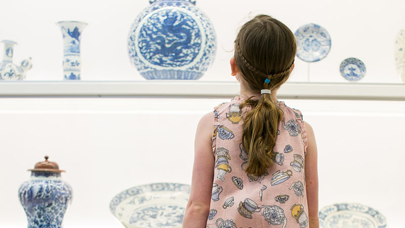 young girl looking at ceramics