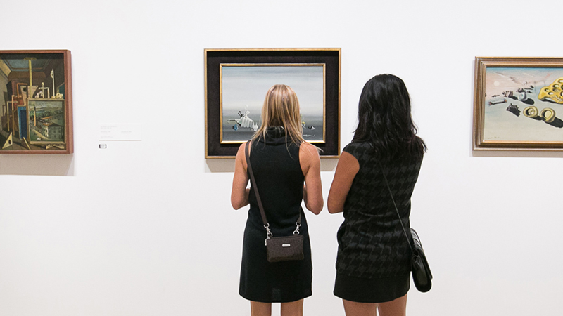two women looking at a painting