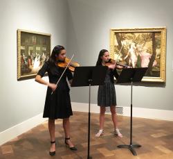 two young women playing violin