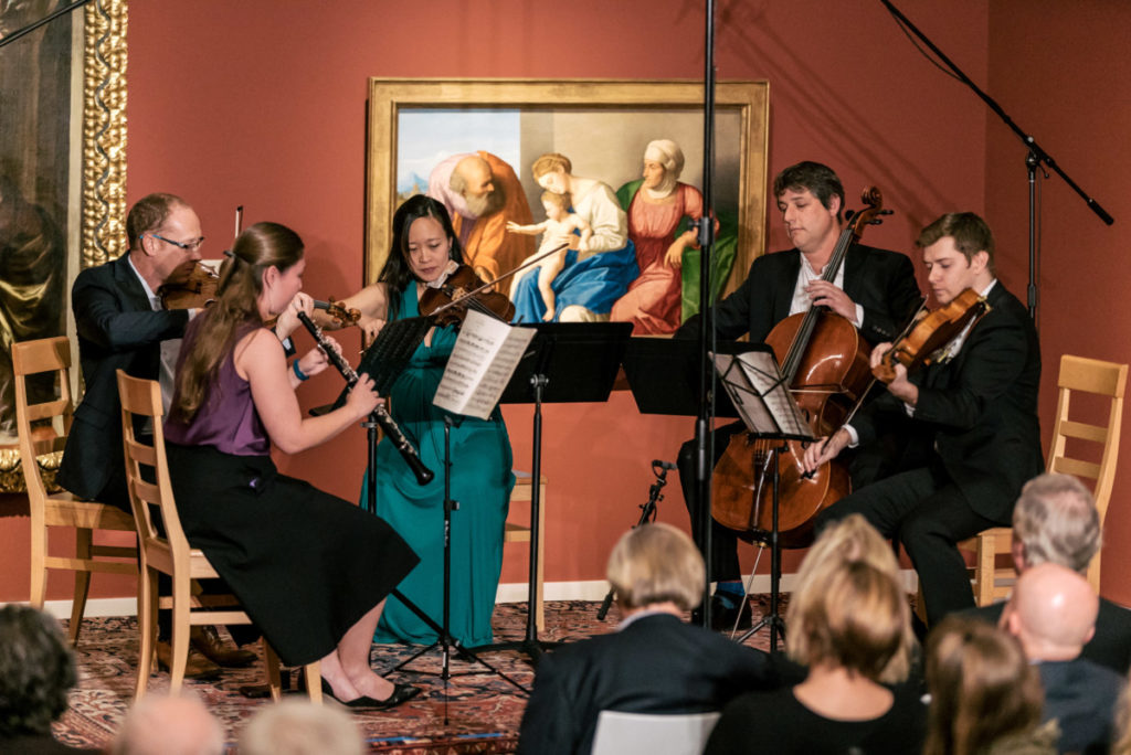 String quartet performing with audience inside art museum gallery