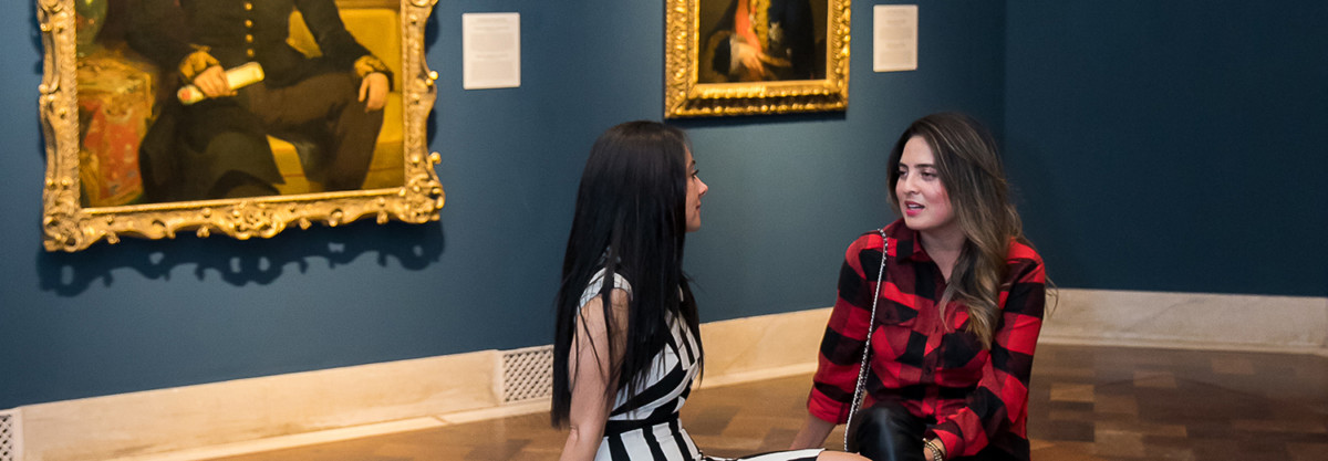 Two women talking in art museum gallery