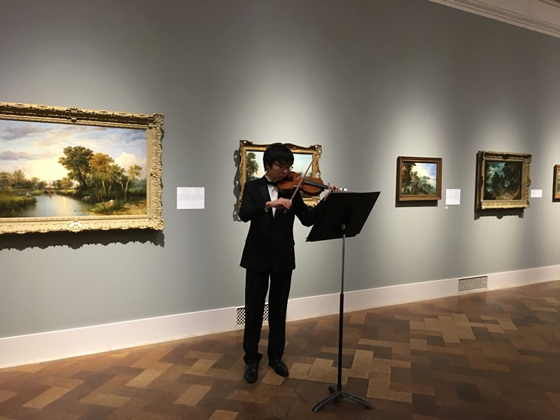 Musician playing violin in art museum gallery
