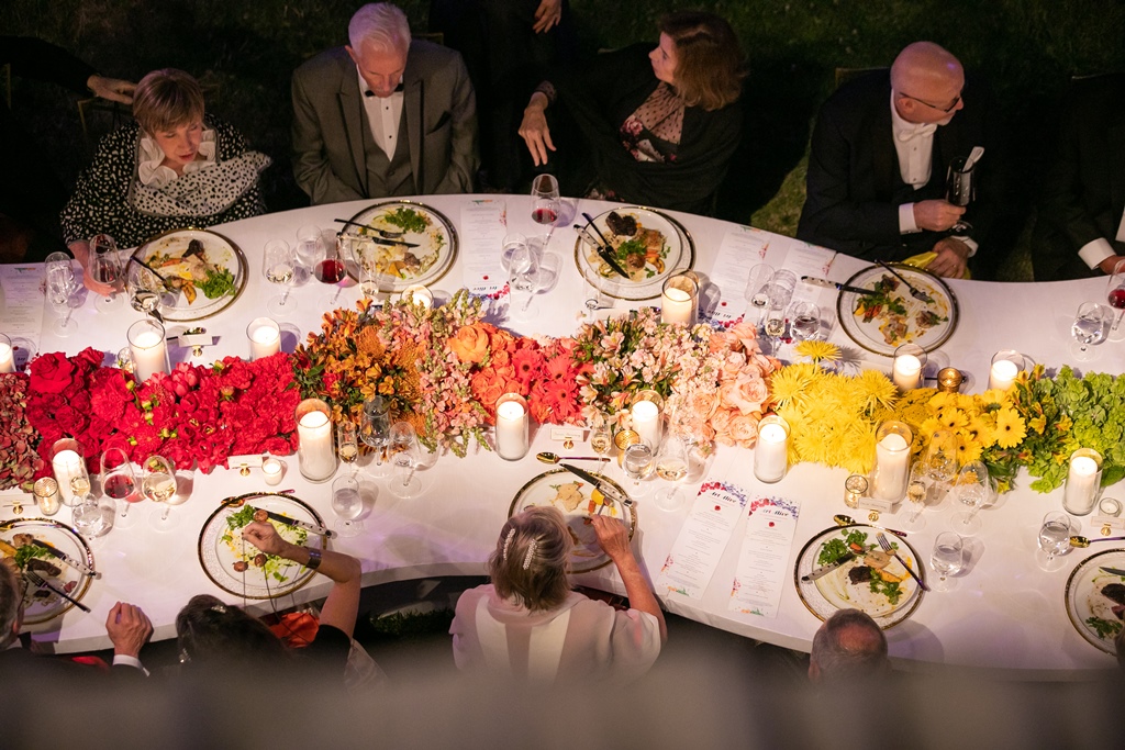 Aerial image of people eating and talking at a black tie dinner
