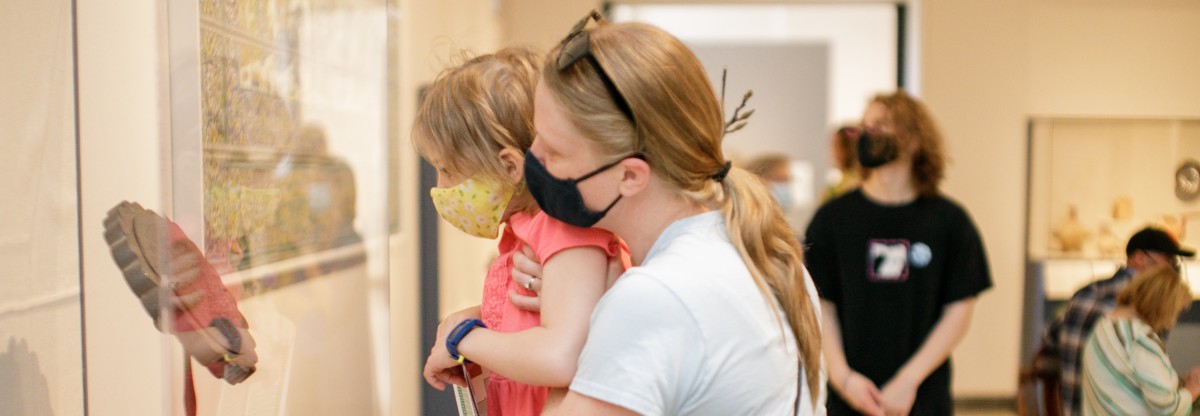 Mother and child looking at art inside museum gallery