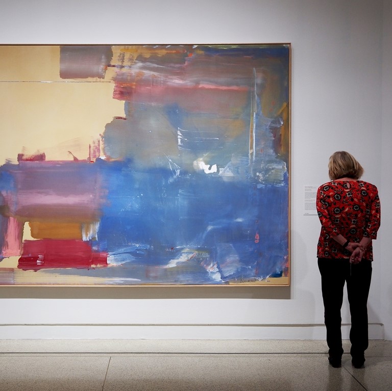 Woman looking at large painting by Helen Frankenthaler