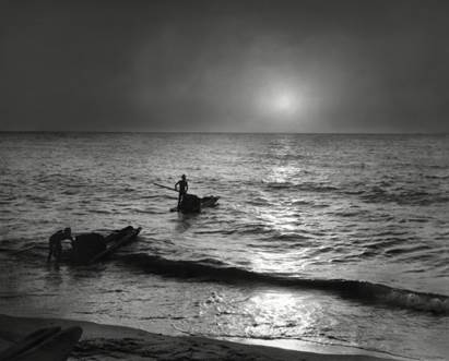 Black and white photograph of two small boats launching out to sea.