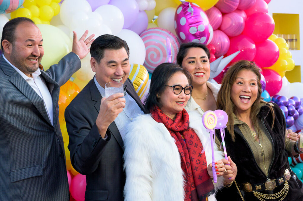 Group of smiling partygoers in front of balloons at Bloom Bash at The San Diego Museum of Art