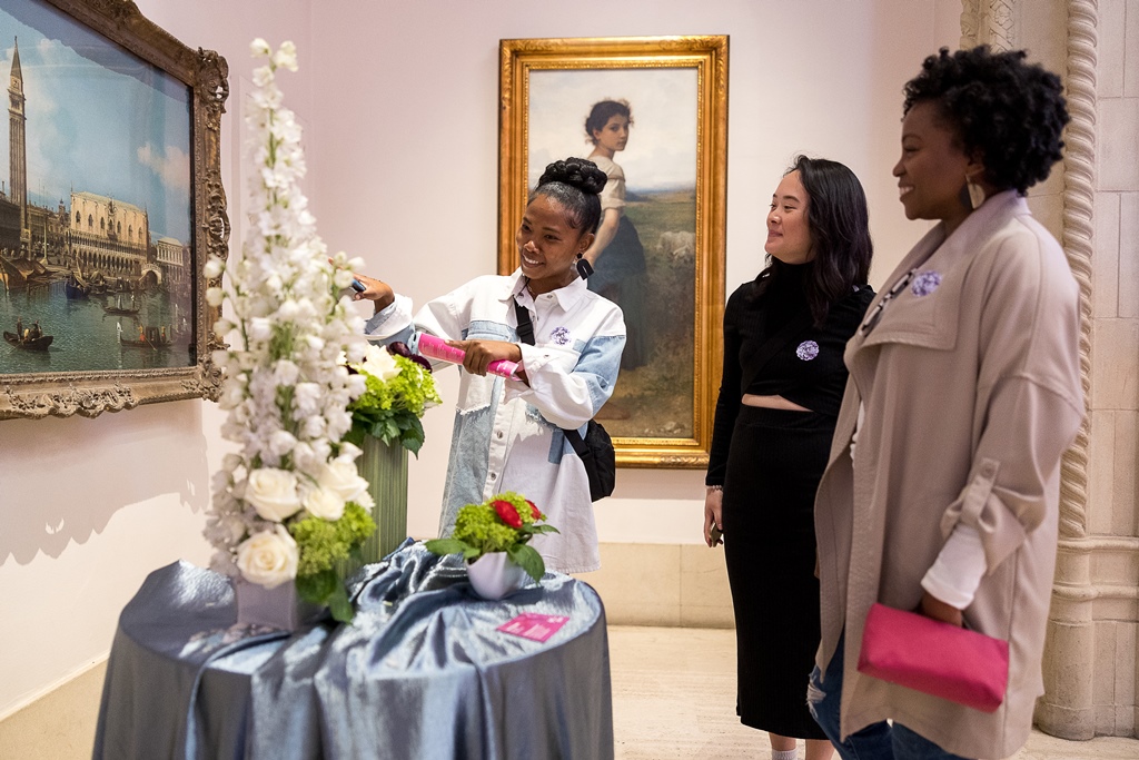 Women looking at floral arrangement and art at Art Alive at The San Diego Museum of Art