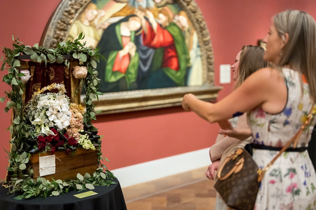 Women looking at and pointing to Art Alive floral interpretation at The San Diego Museum of Art