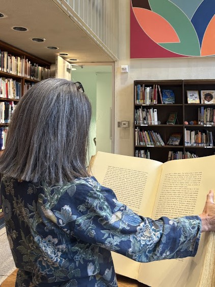 Woman reading oversized book in SDMA Library