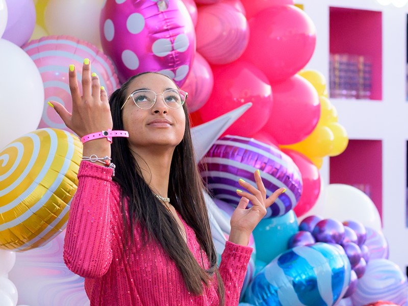 Woman in front of wall of colorful balloons