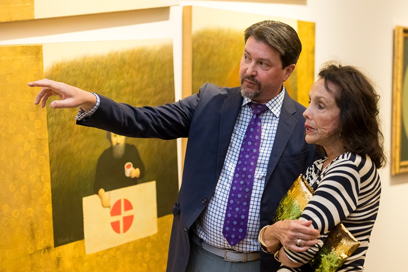 Museum curator and patron talking about art on view