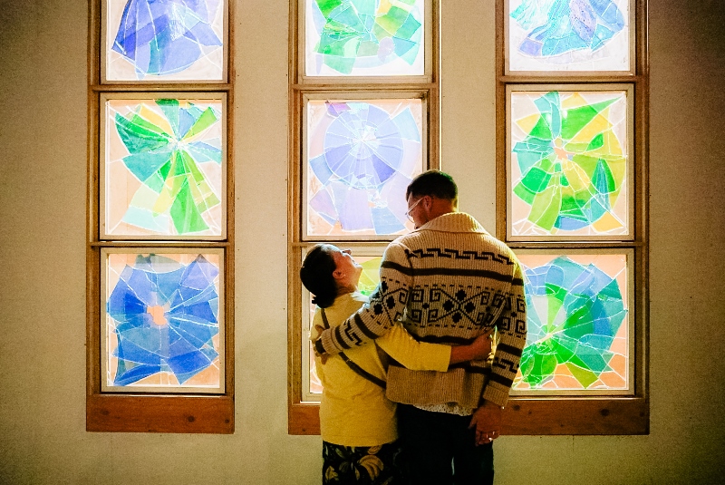 Couple looking at each other in front of glass art installation