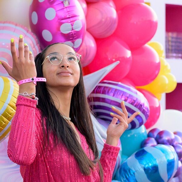 Woman in front of wall of colorful balloons