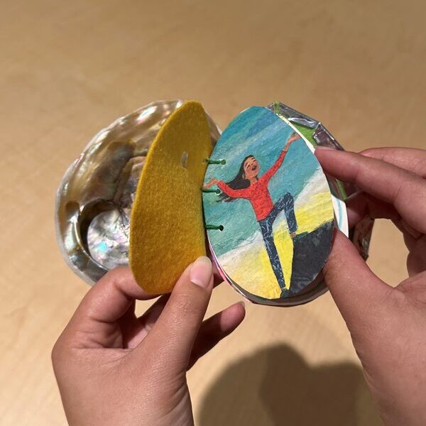 hands holding a handmade book with shell cover