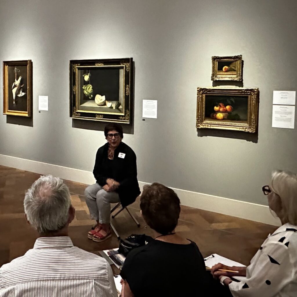 Group tour seated in art museum gallery