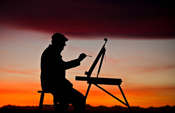 Silhouette of artist painting at easel